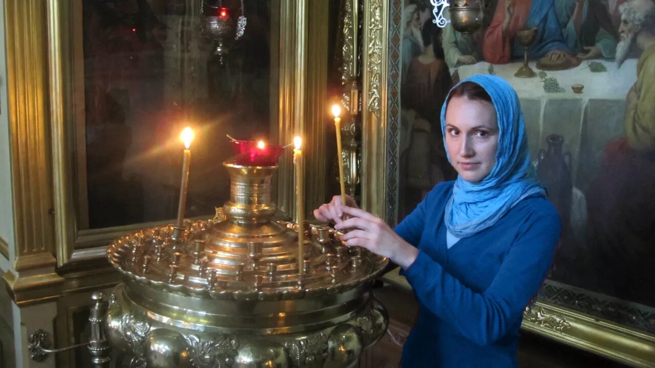 Ставит свечку девушке