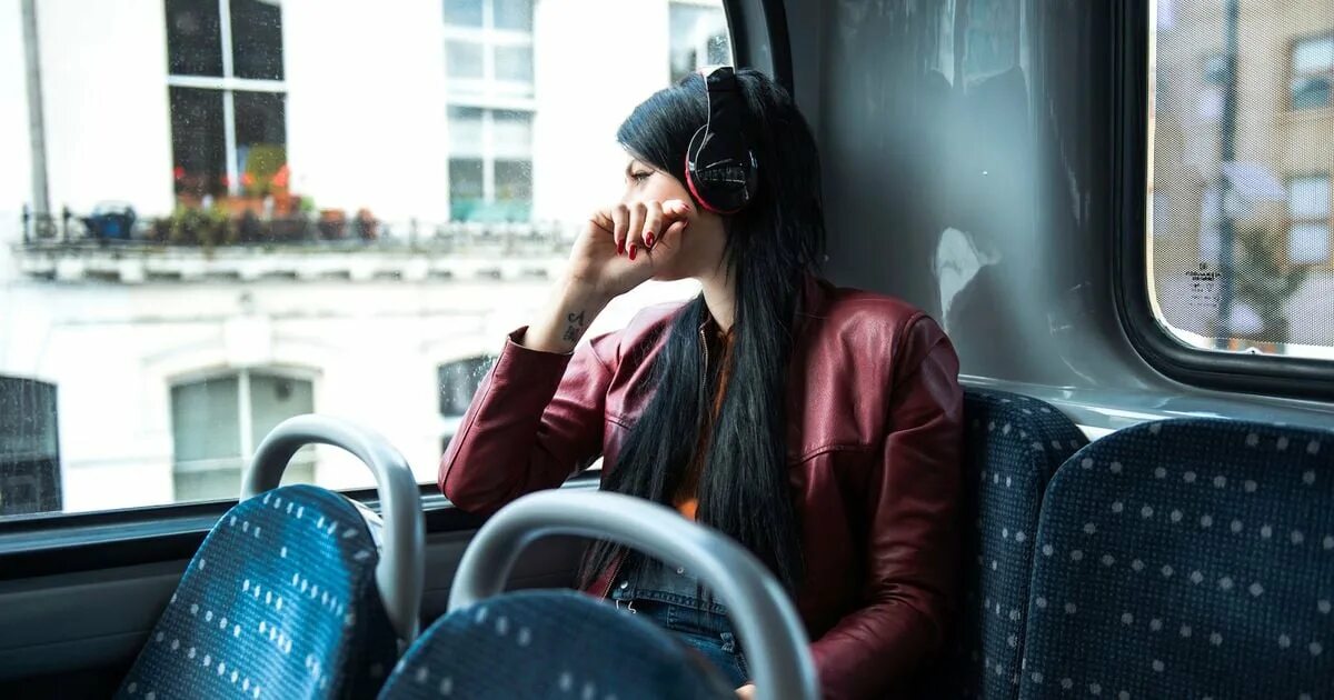 Реклама девушка в наушниках в автобусе. Девушка в автобусе у окна. девушка сидит в автобусе. девушка у окна в маршрутке. человек в окне автобуса.