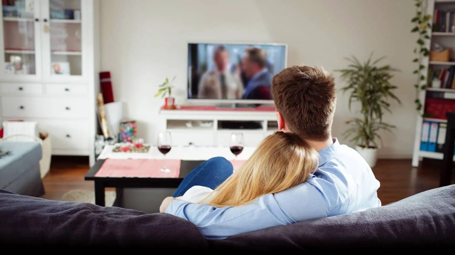 Пока муж смотрит телевизор жена. Пара у телевизора. Пара перед телевизором. Мужчина вечером перед телевизором. Влюбленные на диване.