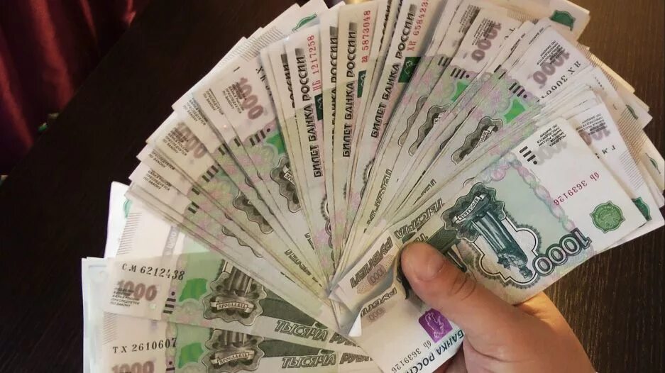 Огромная пачка денег. Много денег на столе. Многодененег в руках. Деньги реальное фото. Рубли в руках.