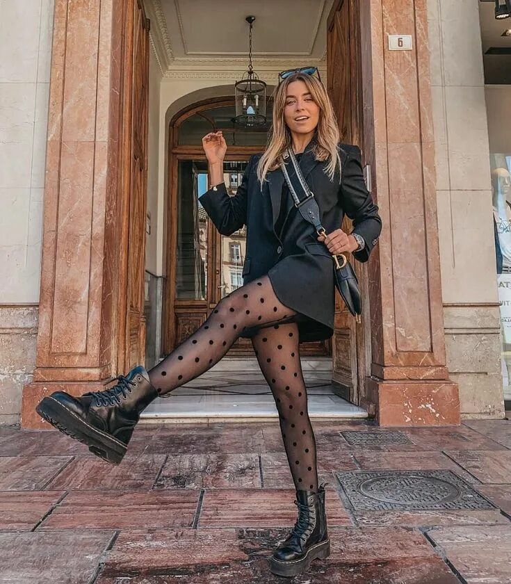 Lais Olivieira in a floral mini dress with black tights and black suede ankle bo