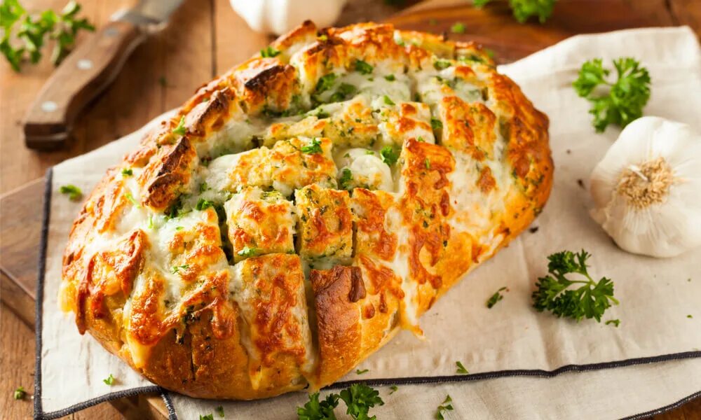 Батон с сыром и чесноком в духовке. Хлеб с сыром в духовке. Чесночный хлеб с сыром. Хлеб с чесноком и зеленью.