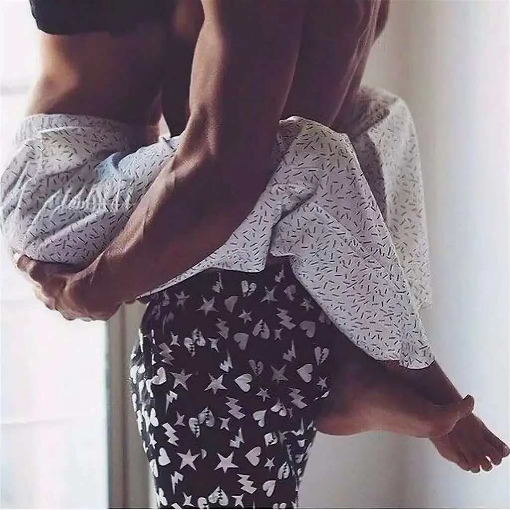 Девушка висит. Обняла ногами. Мужская рука на ноге. Обнимает девушку за талию. Держал за бедра девушку.