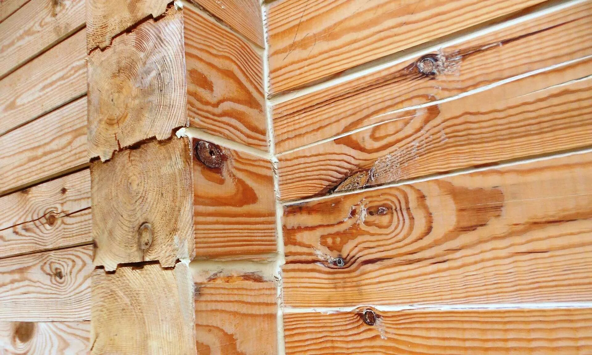 Заделываем трещины в деревянном. Конопатка стен из профилированного бруса 150х150. Конопатка углов профилированного бруса. Щели в доме из бруса. Трещины в профилированном брусе.
