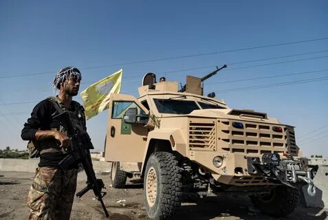 (SDF) fighter stands next an armored vehicle, at al-Sabha town in the easte...