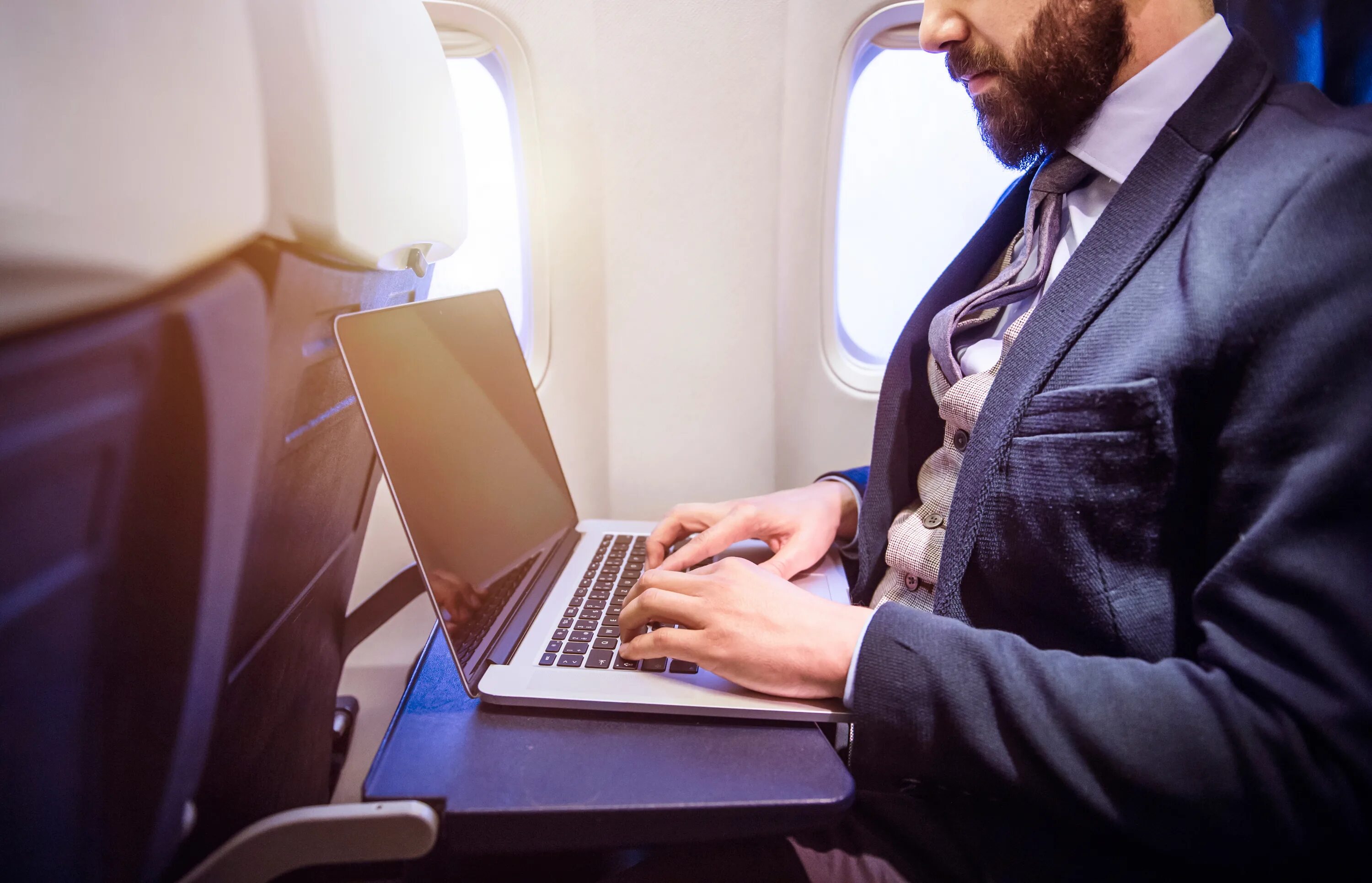 Бизнес класс иванов. Бизнесмен с ноутбуком. Бизнесмен с планшетом в самолете. Мужчина в самолете. Человек с ноутбуком.