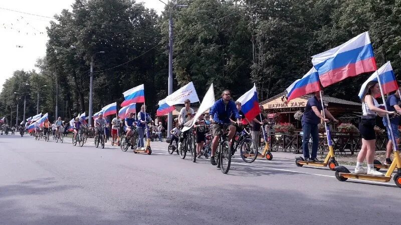 Общественные движения в рязани. Флаг России на велосипеде. Лесопарк Рязань флаг России. День велосипеда. Держит флаг России.