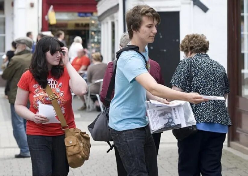 Leafleting. Handing out Flyers. Handing person. Giving Flyer. Handling out