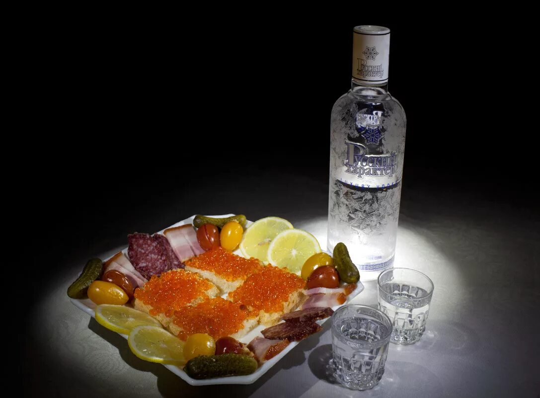 Натюрморт с водкой. Рюмки налитые. Шампанское наливают в бокал. Водка в стопке и закуски. Рюмочка водки.