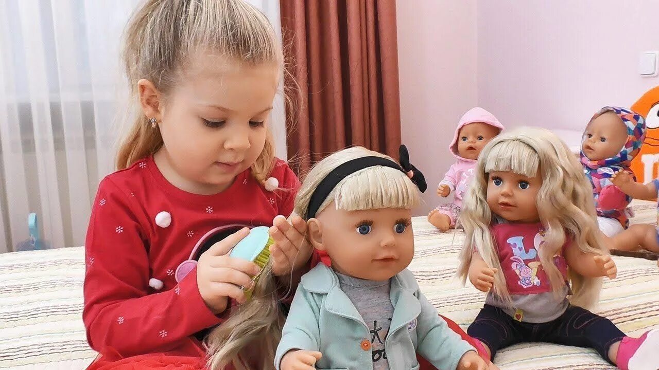 Девочка причесывает куклу. Кукла малыш с волосами. Девочка расчесывает куклу. Ребенок расчесывает куклу.