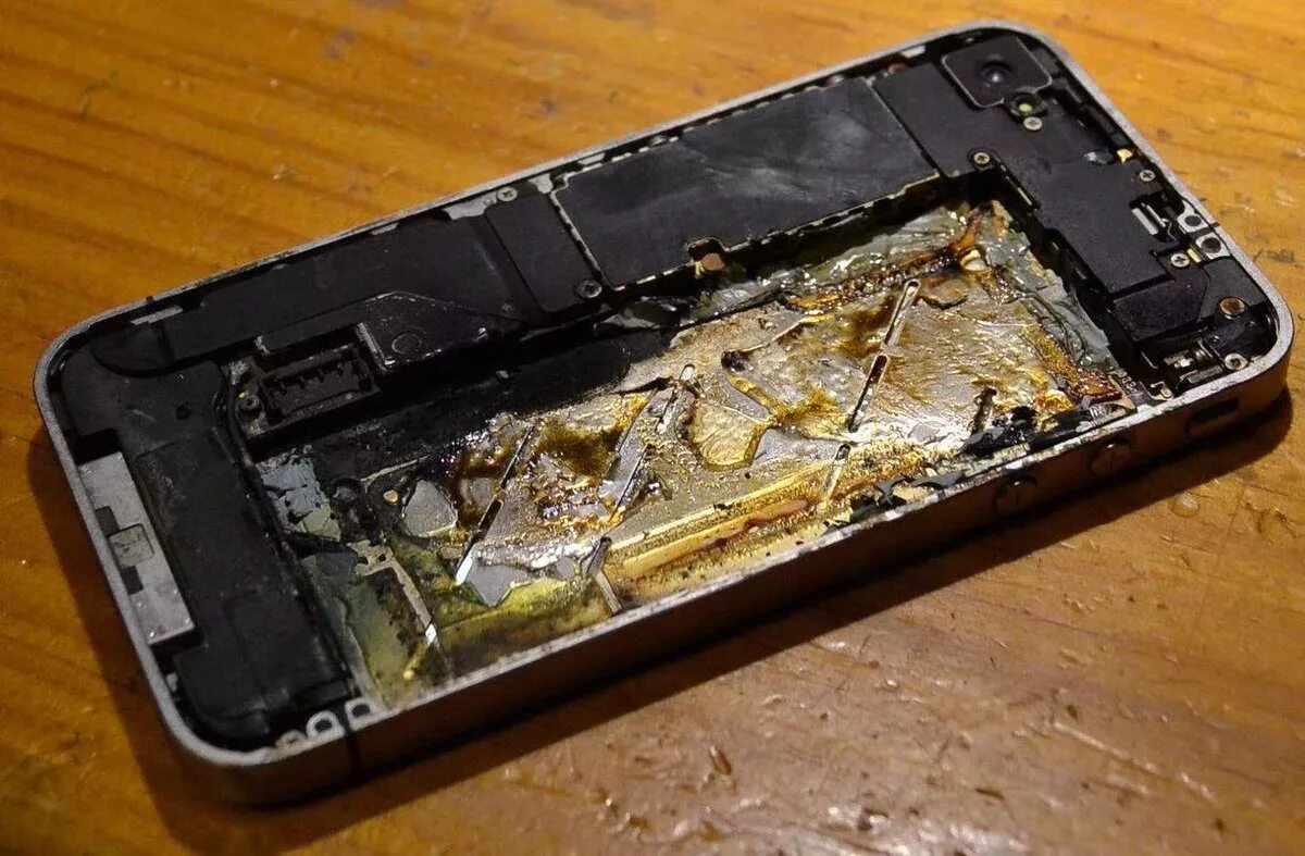 Разбитый мобильный телефон. Айфон сгорел. Разбитый смартфон. Сломанный смартфон. Сгоревший аккумулятор.