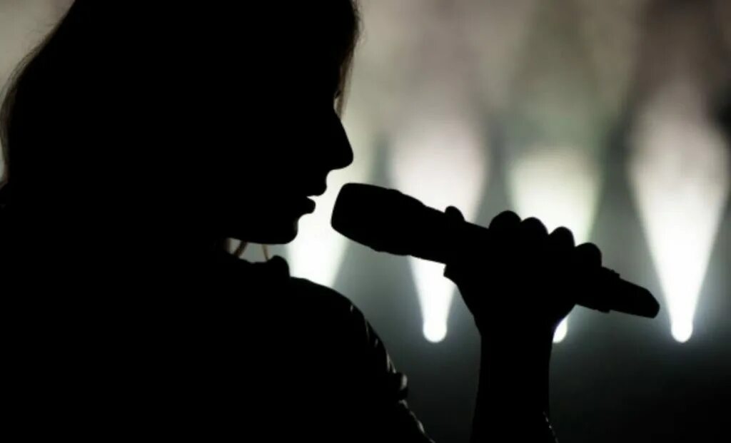 Медленно поет. Девушка с микрофоном. Девушка на сцене с микрофоном. Певица с микрофоном. Человек на сцене с микрофоном.