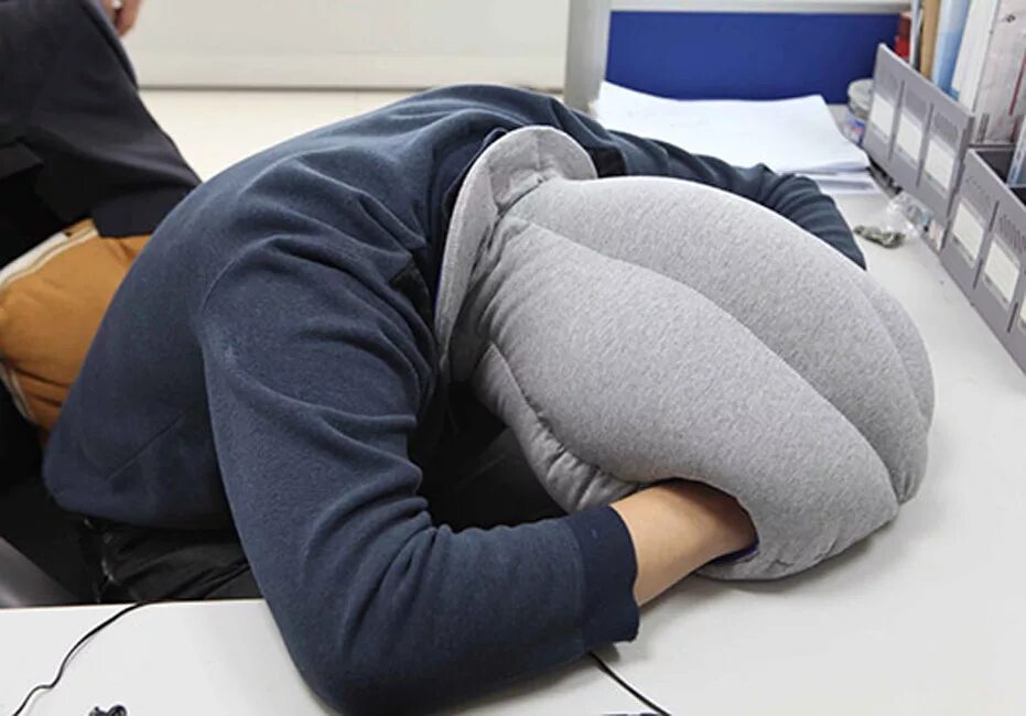 Спать головой в подушку. Подушка-страус Ostrich Pillow. Подушка сон. Подушка для сна в офисе. Подушка для сна на столе.