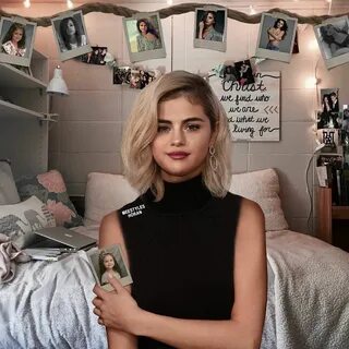 a woman holding a book in her hands while standing next to a bed with pictu...