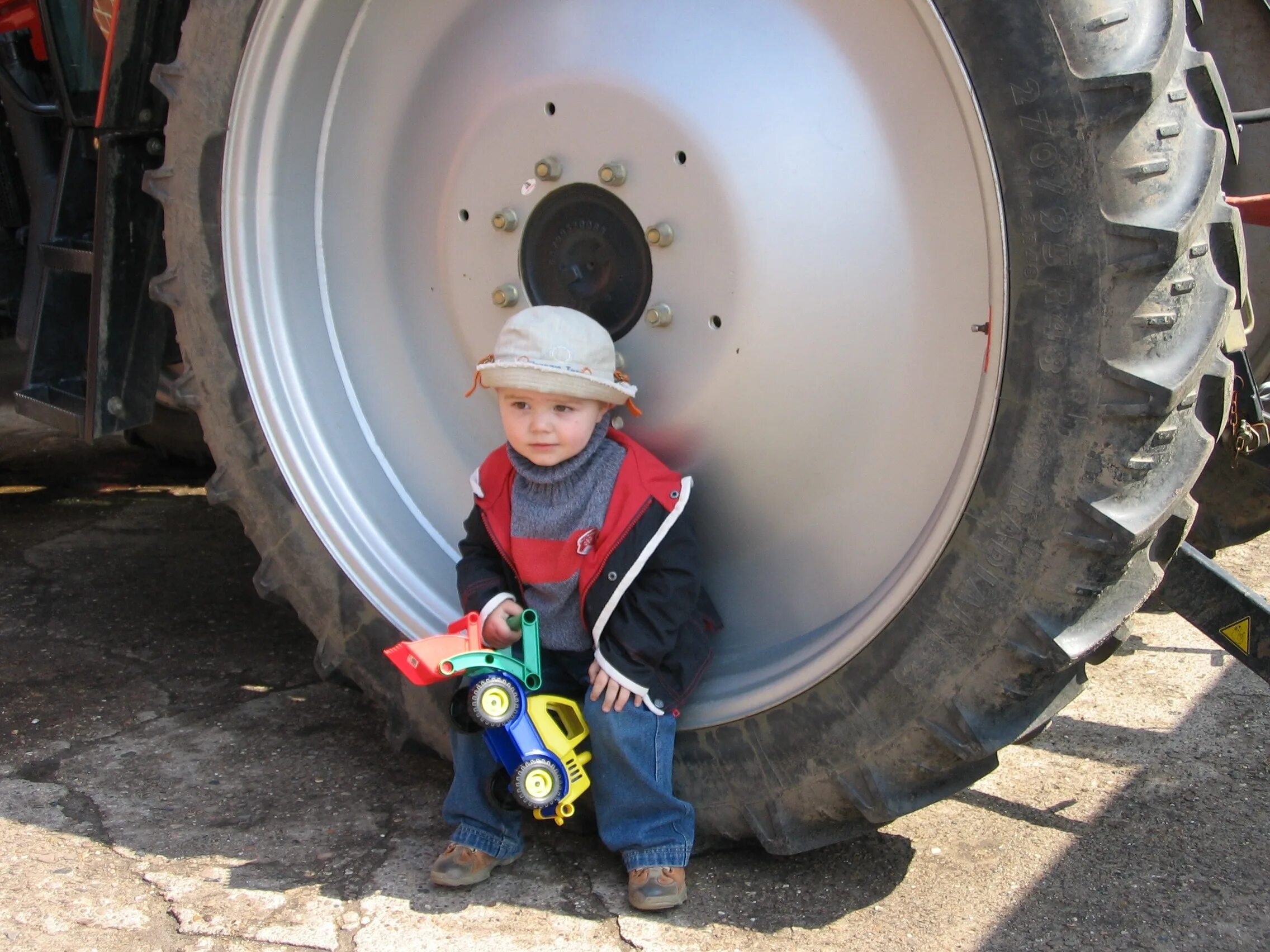 Колесо трактора. Трактор для мальчиков. Колесо трактора с человеком. Детская фотосессия с трактором. Маленькие дети трактор
