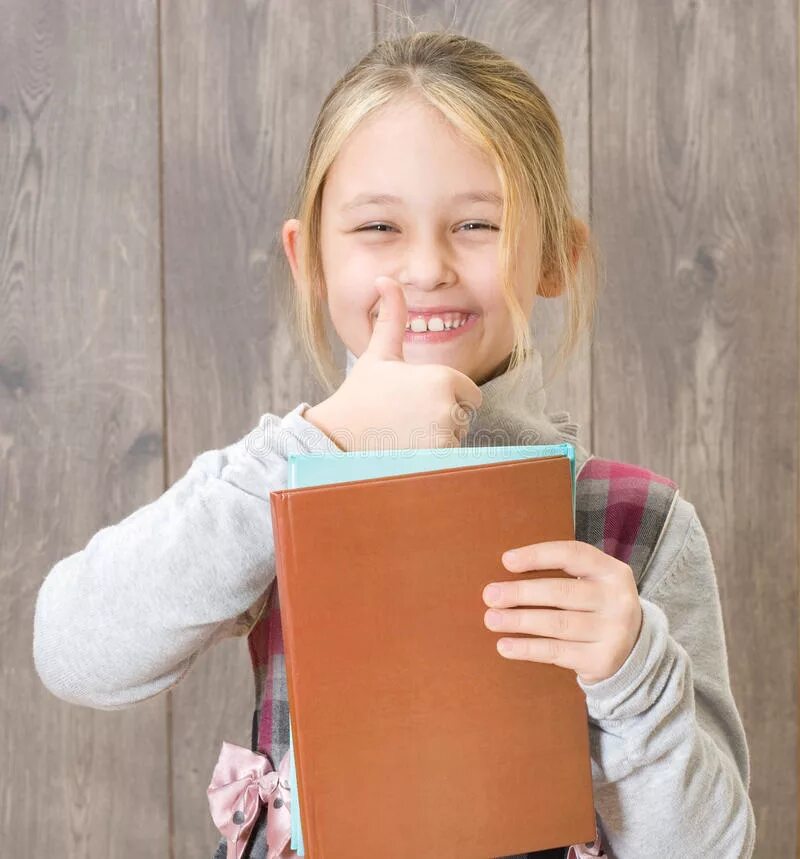 Ребенок с книгой в руках. Девочка держит книгу фотосток. Девочка держит в руках книгу. Девушка держит книгу. Девочка держит книгу на голове.