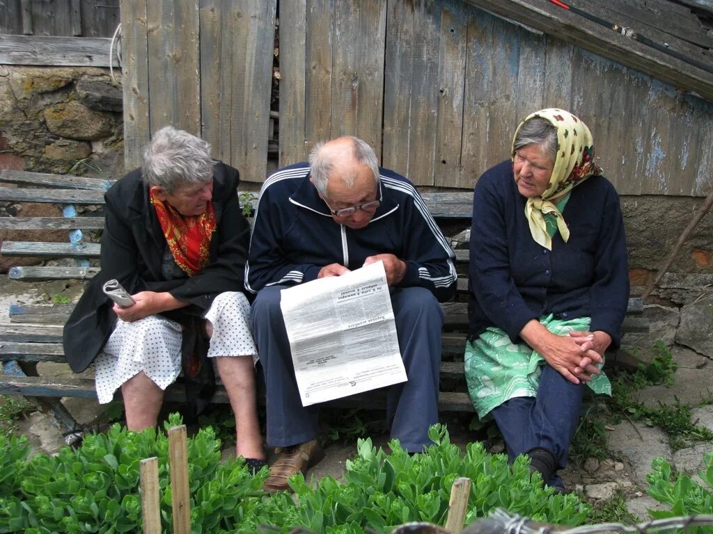 Читающее село. Бабушка читает газету. Жители в деревне работают. Крестьяне читают газету. Чтение газеты.