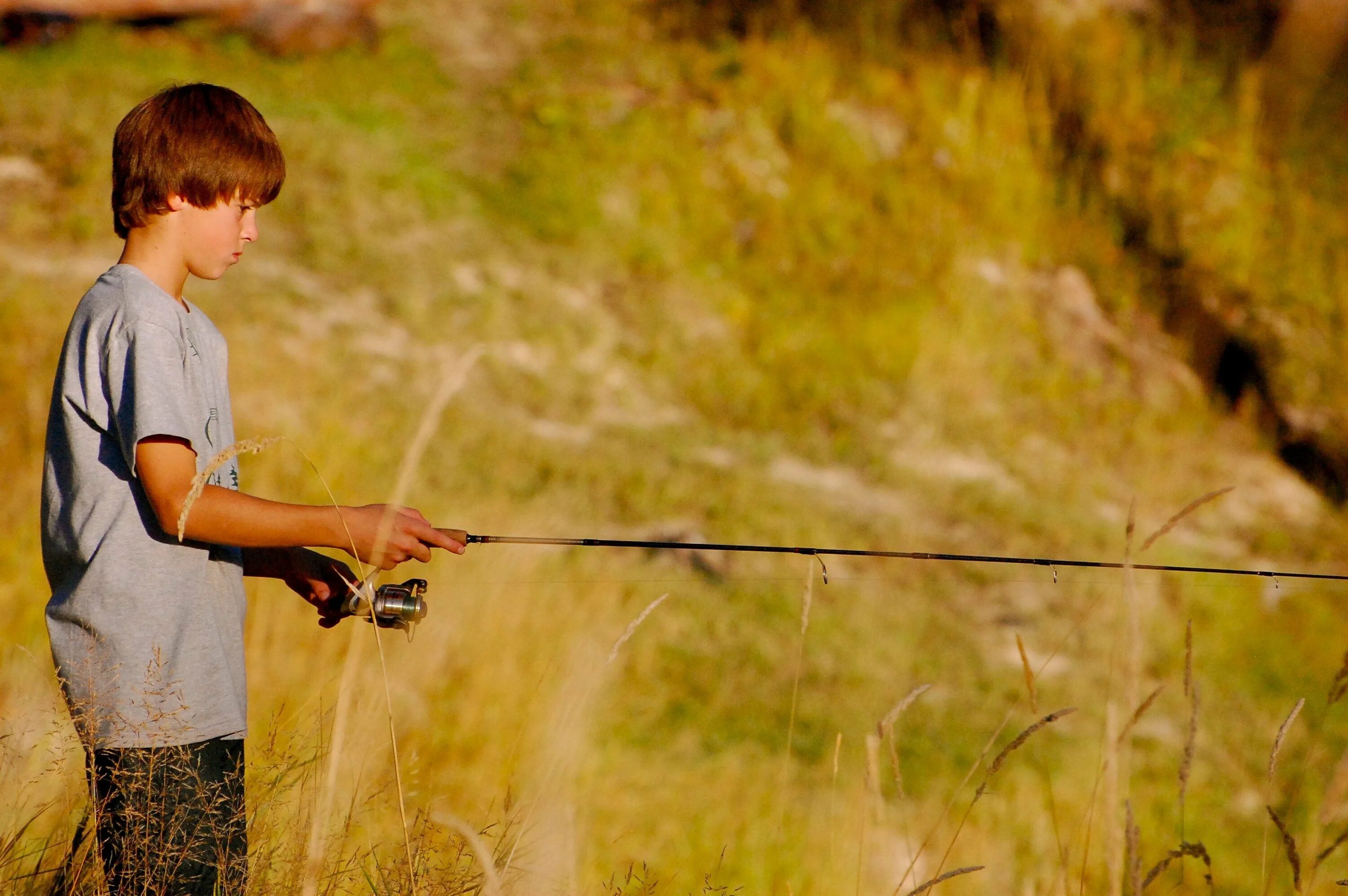 Ловят подростков. Мальчик рыбачит. Мальчик Рыбак. Мальчик поймал рыбу. Подросток на рыбалке.