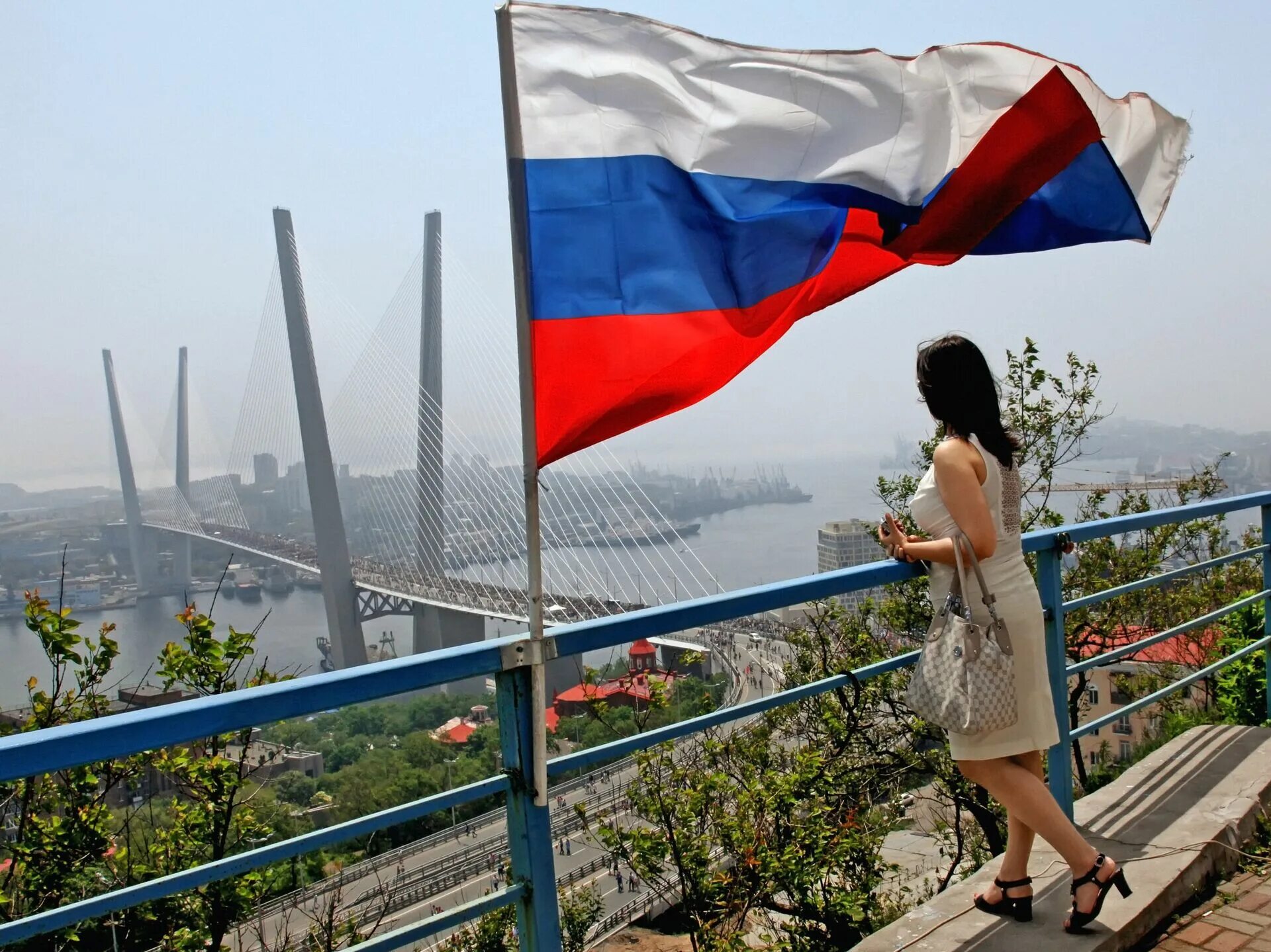 Флаг России Владивосток. Самый большой флаг России Владивосток. Девушка с флагом России. Флаги на мосту. День россии владивосток