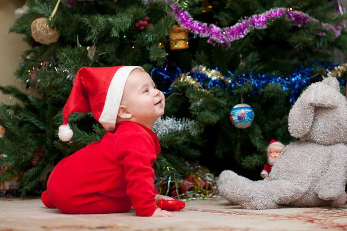 Дети под елкой. Елка для детей. Новогодняя елка с маленьким ребенком. Дети возле елки. Детский новогодний елка