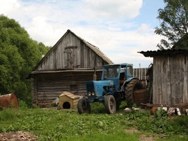 Мод жизнь в деревне. Хозяйство в деревне. трактор в деревне. жители сельской местности. старый трактор в деревне.