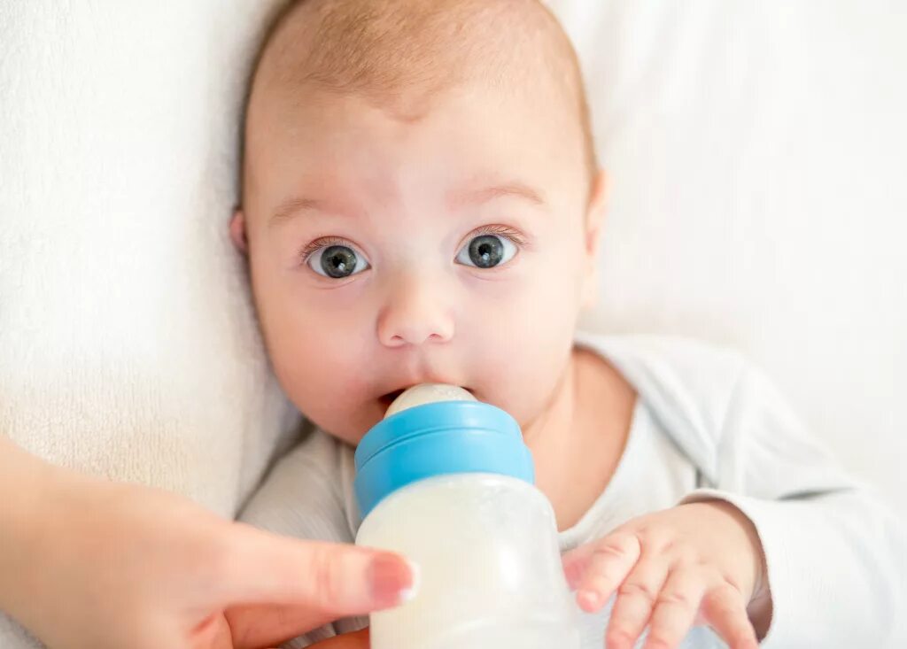 Ребенок. Младенец с бутылочкой. Кормление из бутылочки. Малыш пьет бутылочка. Почему грудным детям нельзя