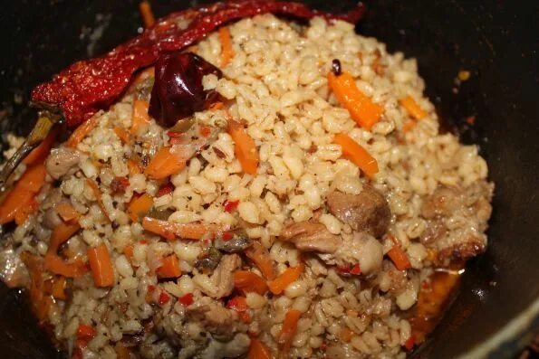 перловая каша. каша из перловки. перловая каша с мясом в казане. перловая каша в чугунке. плов из перловки с мясом в казане.