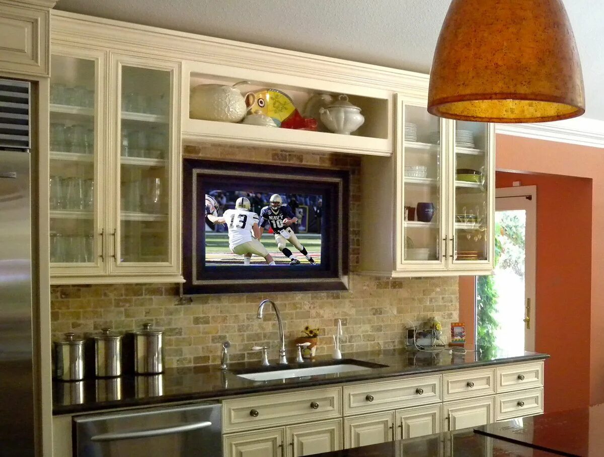 Включи телевизор на кухне. Телевизор на кухне. Кухонный гарнитур с телевизором. Телевизор в кухонном гарнитуре. Телевизор встроенный в кухню.