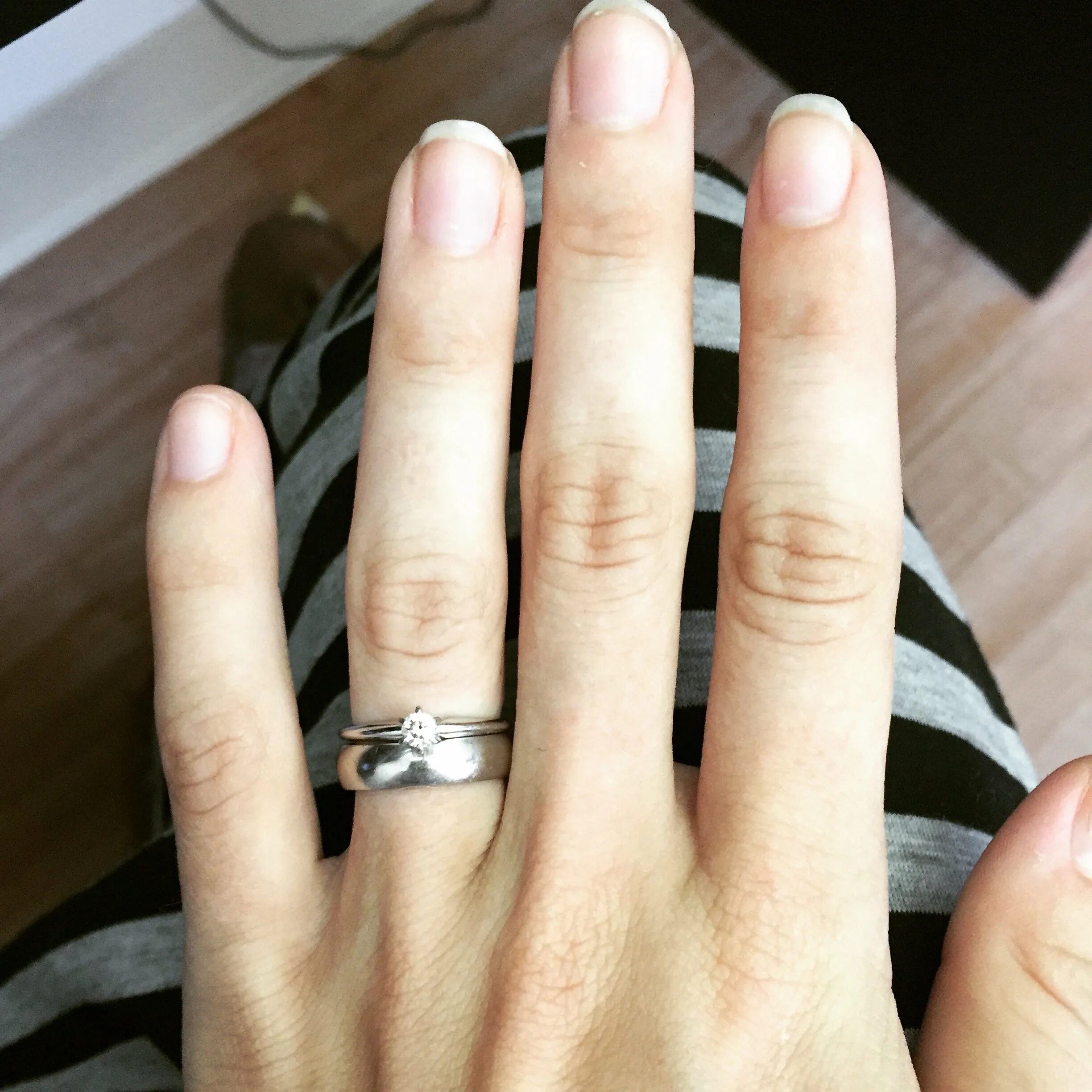 Тонкое обручальное кольцо на пальце. Плоские обручальные кольца на руке. Современные обручальные кольца на руке.
