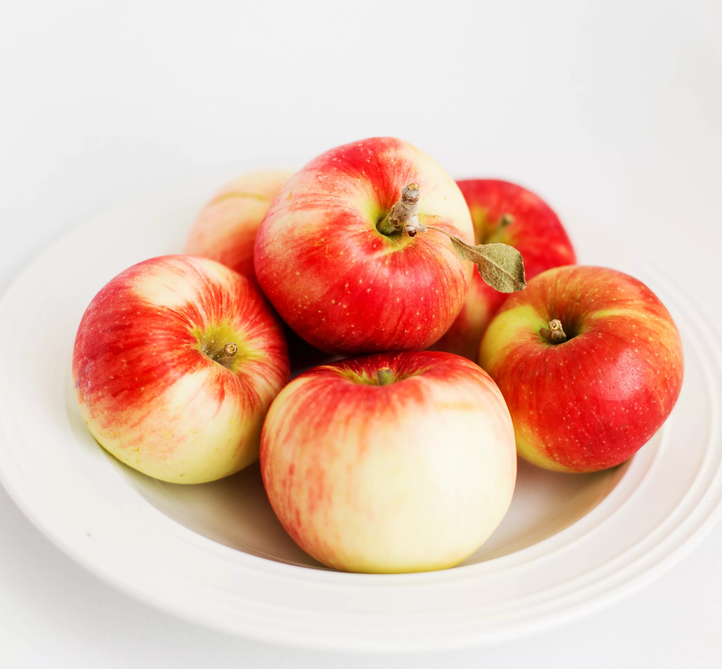 В 2 вазах по 18 яблок. Яблоко на тарелке. Яблоко на белом фоне. Яблоки красные.