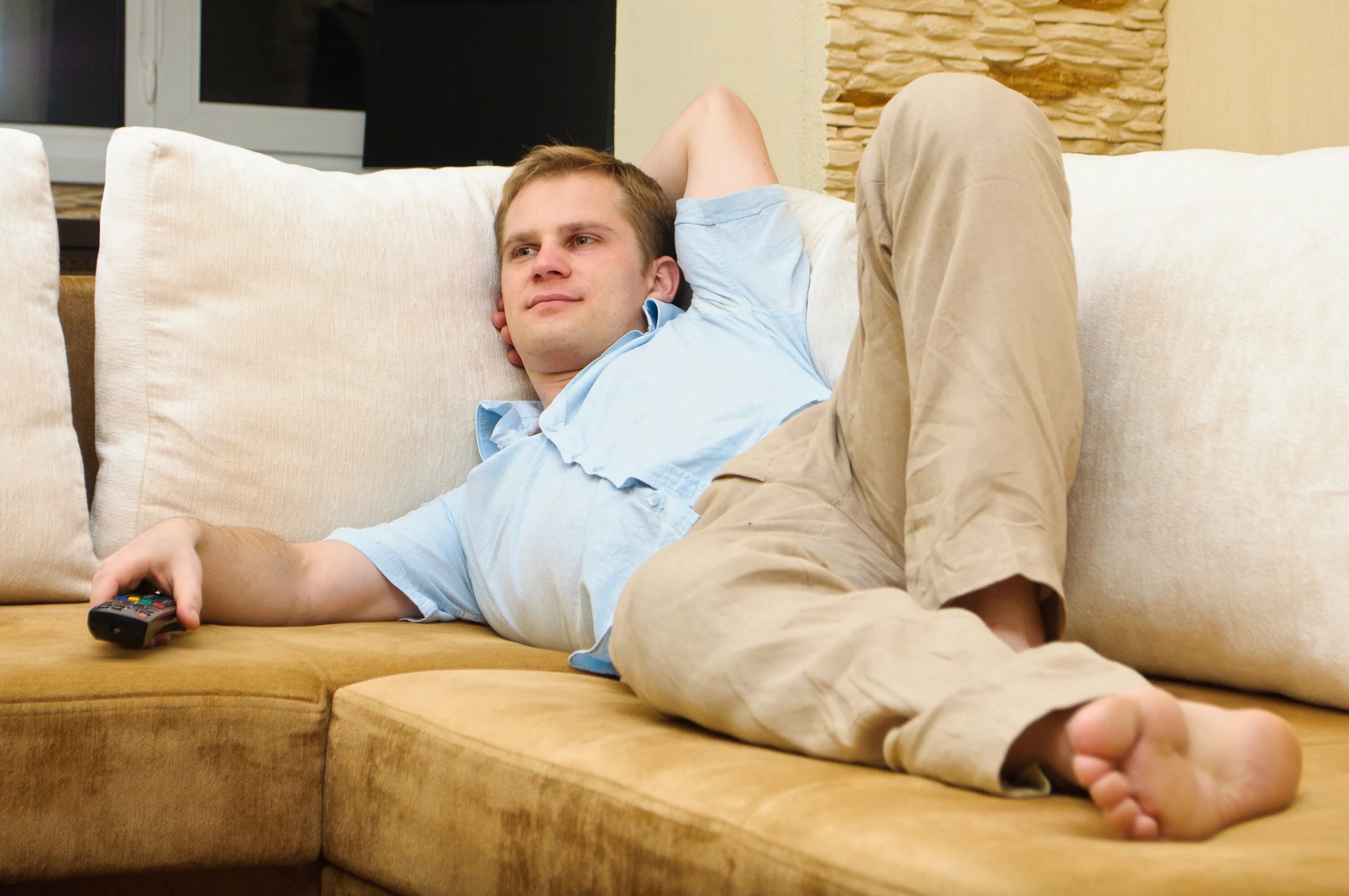 Сижу перед телевизором. Лежит на диване. Человек лежит на диване. Человек отдыхает на диване. Мужчина на диване.
