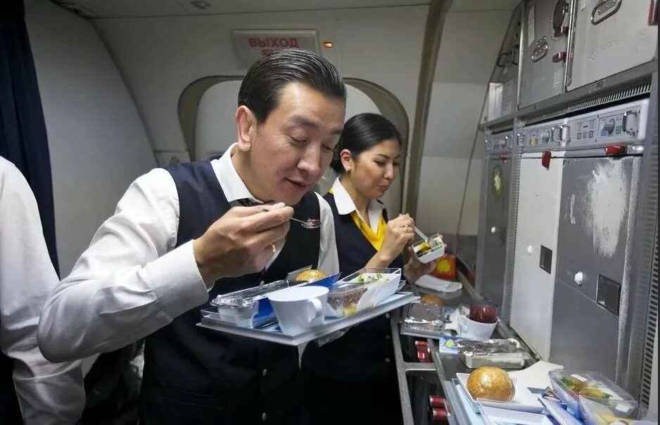 Самолете дают еду. Еда в самолете. Стюардесса с едой. Стюардесса с едой в самолете. Питание экипажа в самолете.