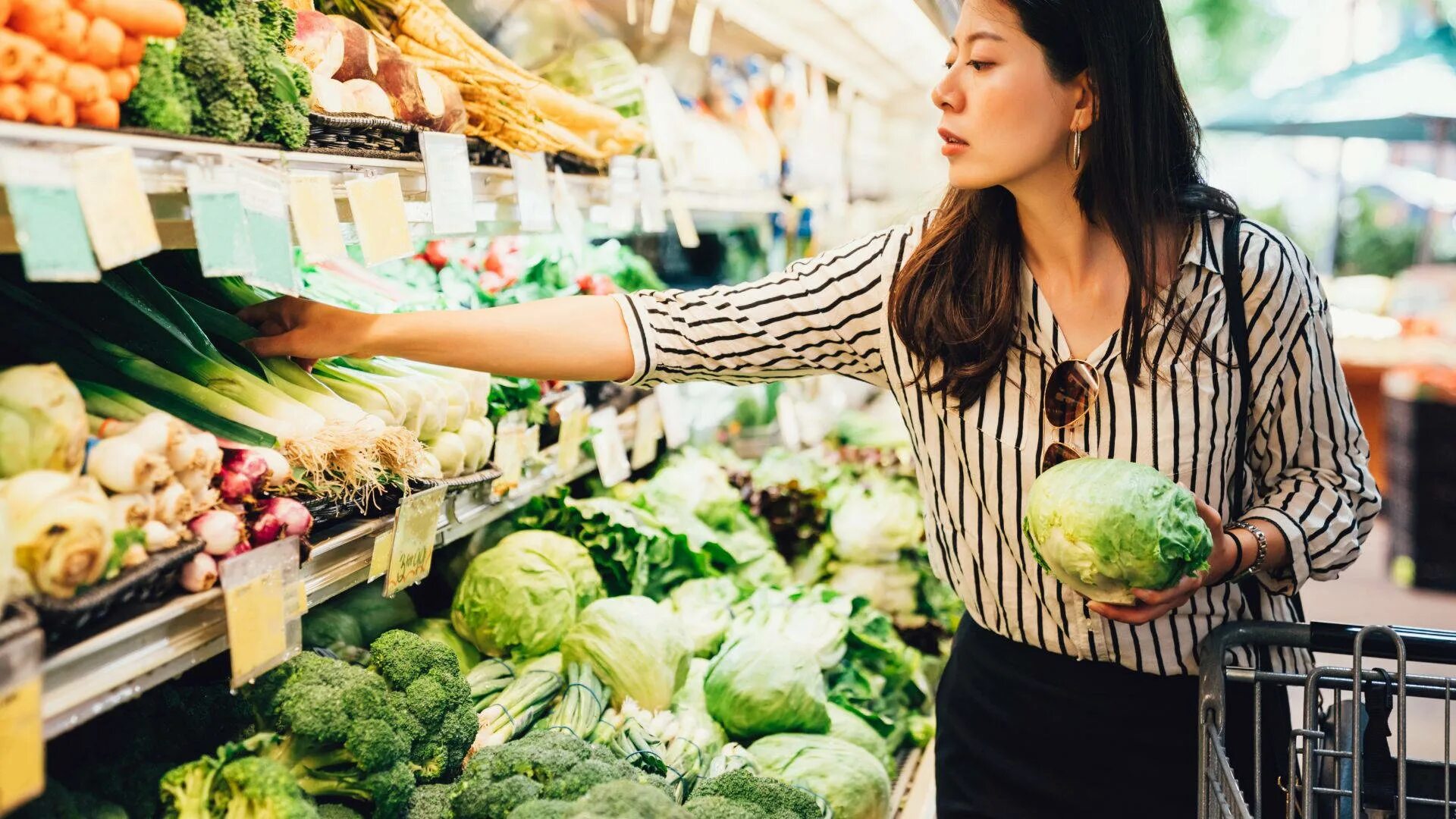 Find vegetables. Овощи и фрукты в супермаркете. Овощи в магазине. Девушка с продуктами. Девушка выбирает овощи.