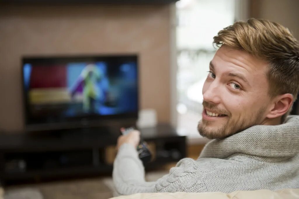 Сегодня по телевизору есть какие. Мужчина у телевизора. Мужчина смотрит телевизор. Человек телек. Люди смотрят ТВ.