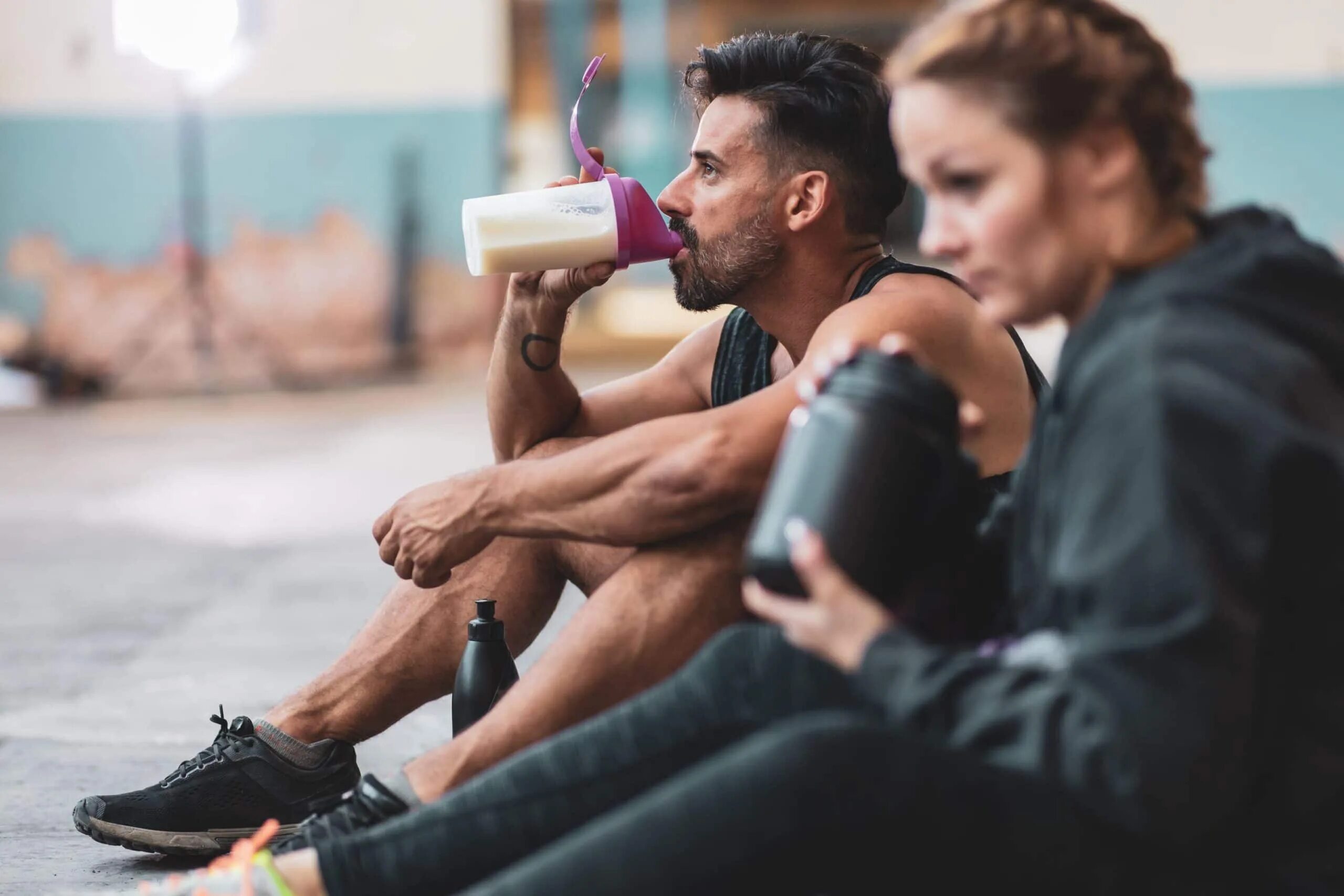 Напитки после тренировки. Питание и тренировки. Спортсмен пьет. Спортивное питание для спортсменов. Мужчина пьет протеиновый коктейль.