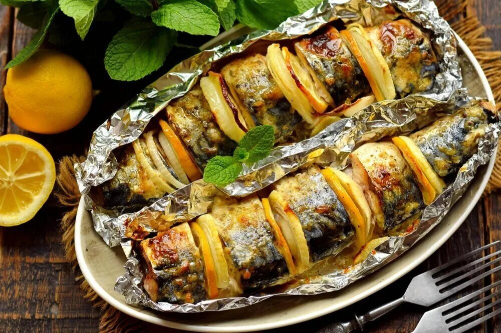 При какой температуре запекать скумбрию в фольге. Скумбрия запеченная с лимоном и луком. запеченная макрель. рыба скумбрия в духовке в фольге. скумбрия фаршированная луком.