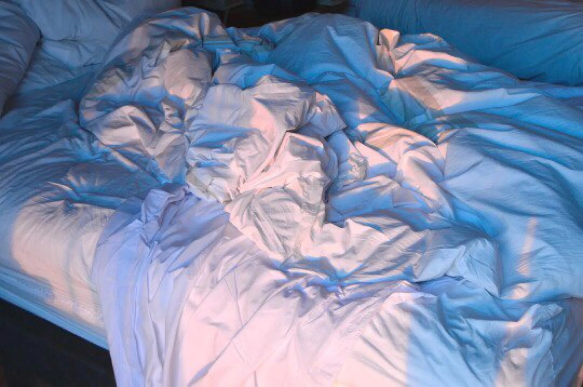 Смятая белая постель. Складки на одеяле. Мятая кровать. Кровать сверху. Смятая простынь.
