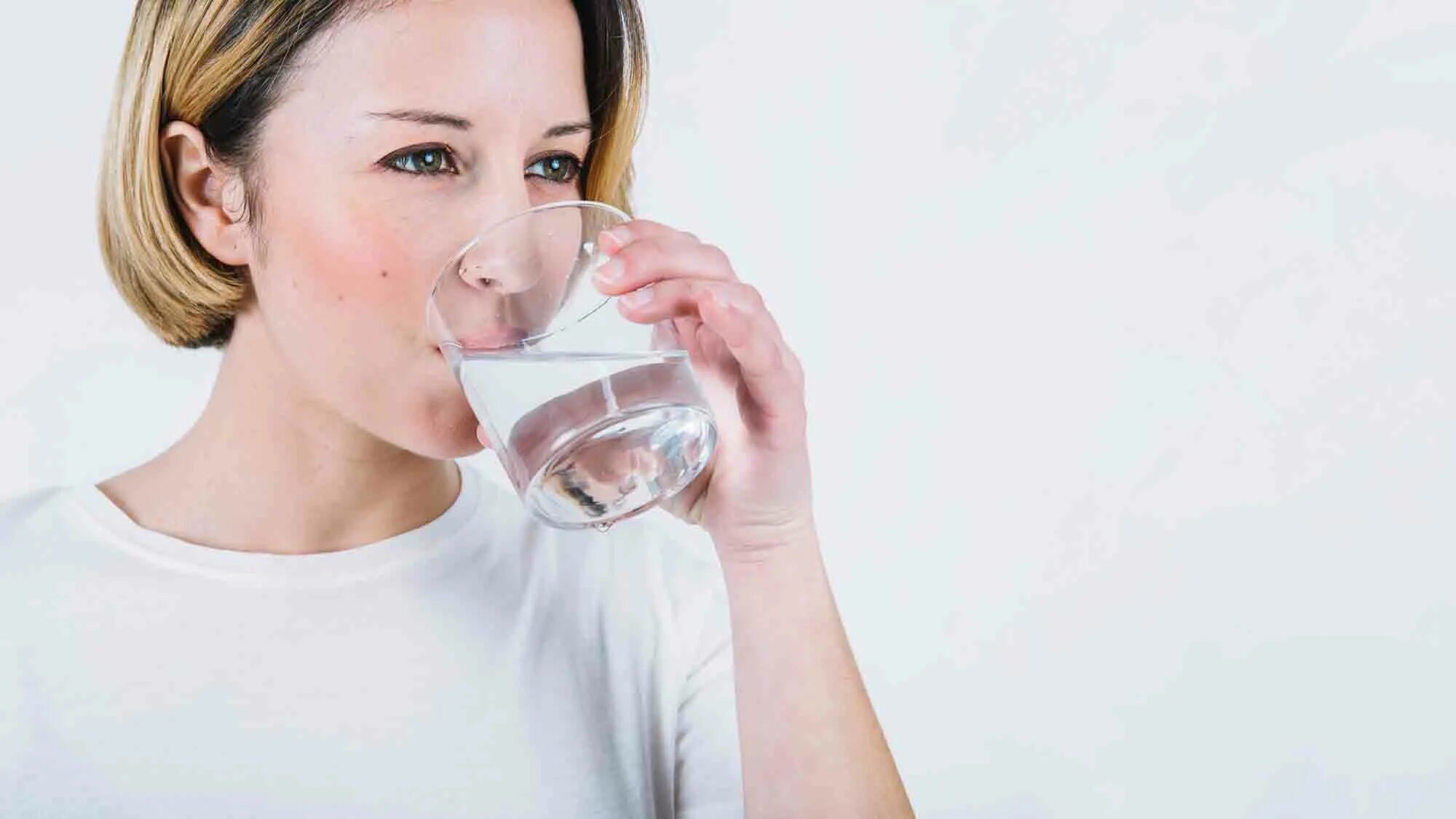 Женщина пьет воду. Женщина пьет воду из стакана. Девушка со стаканом воды. Человек пьет воду. Белый попить