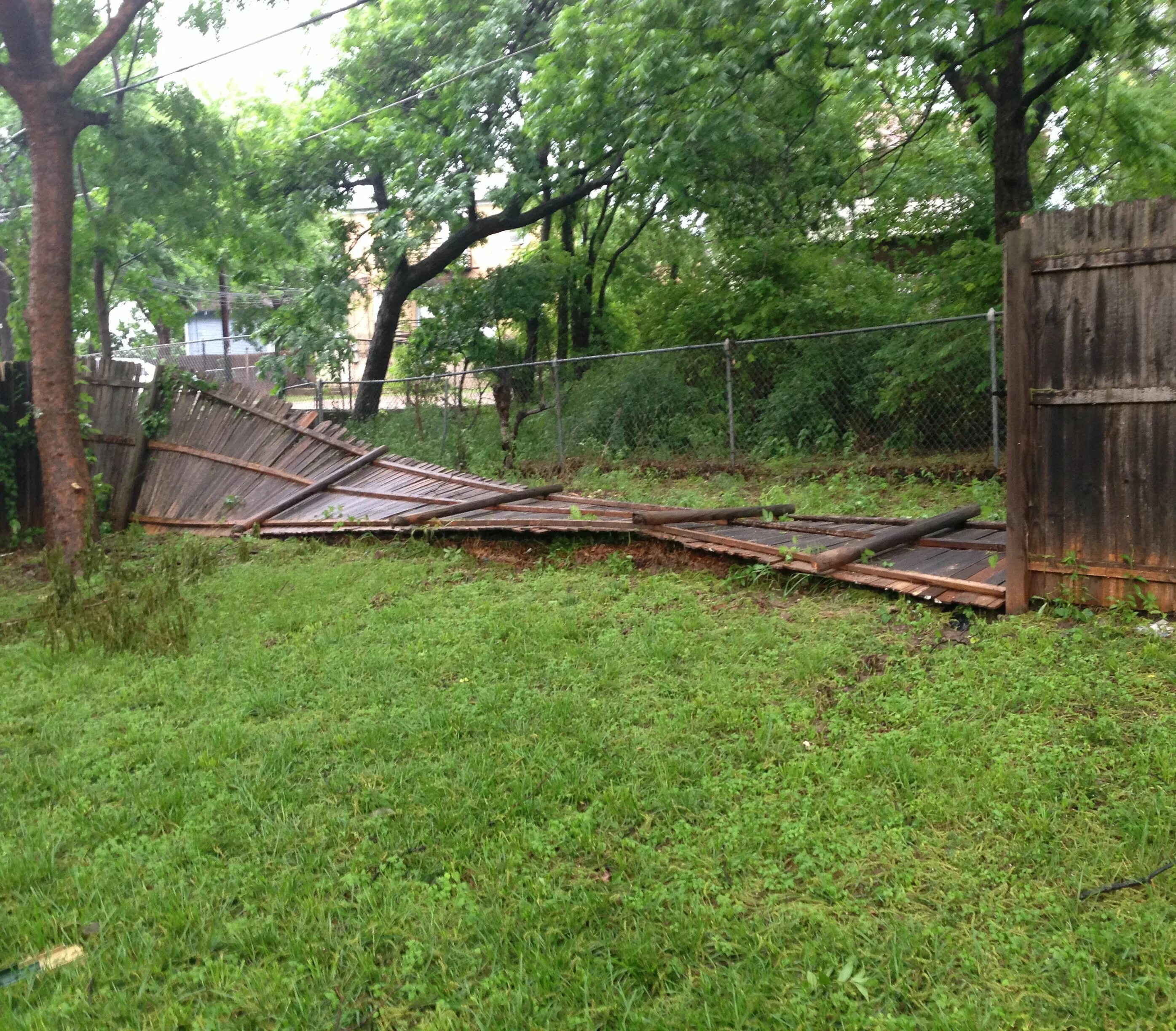 Покосившиеся столбы забора. Упал забор на даче. Низ забора. Сломанные заборы из профнастила. Упавшие заборы.