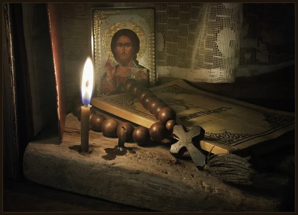 Молитвослов великого поста. Монах молится. Икона и свеча. Свеча перед иконой Христа.
