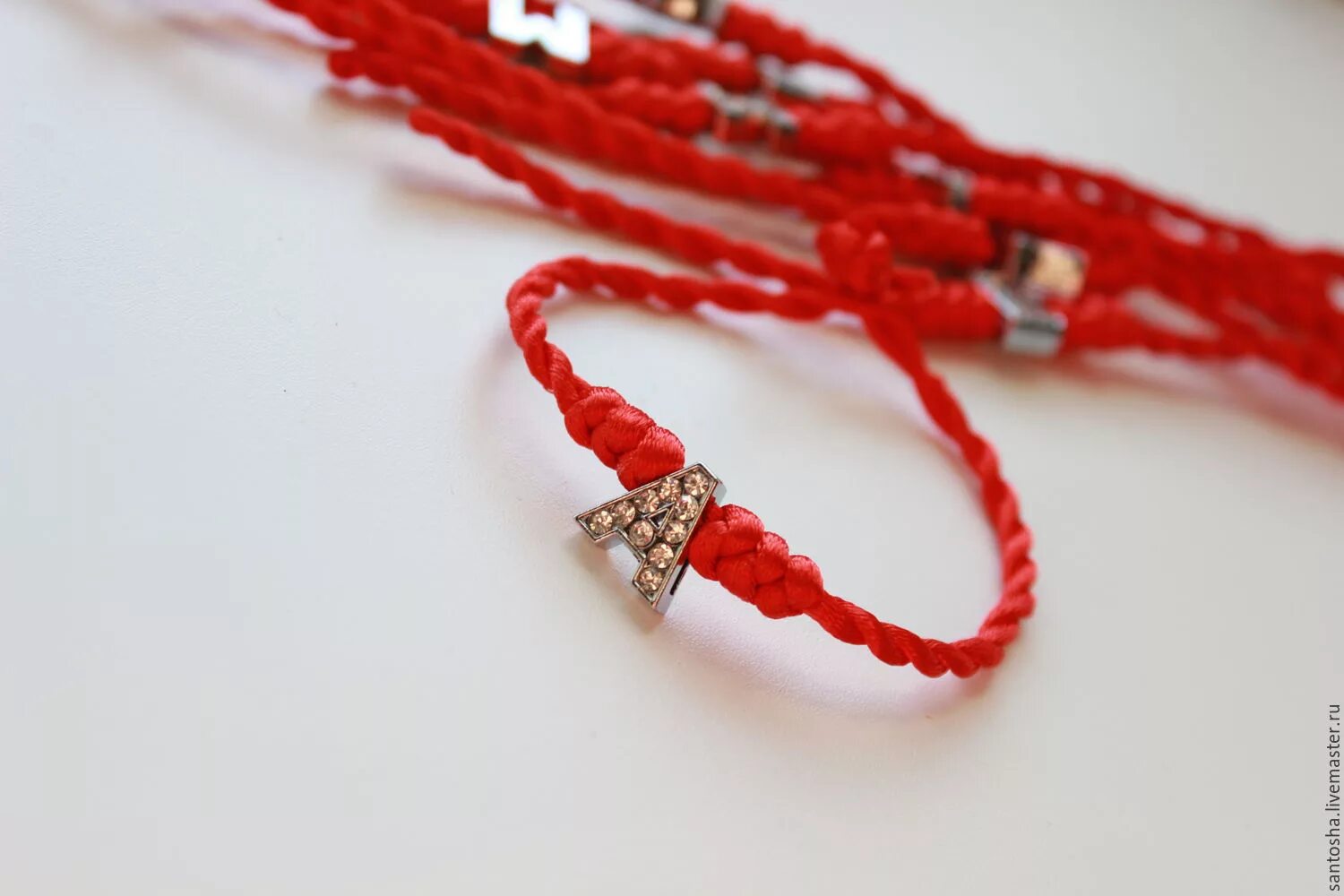 что делают с красными нитками. красная нитка на руке. красная нить на руке. что делают с красными нитками. красный плетеный браслет.