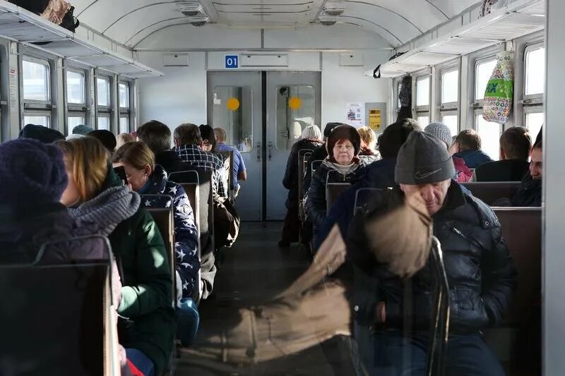 Едет утром в электричке. Электричка. Пассажиры в поезде. Люди в электричке. Пассажиры пригородных поездов.