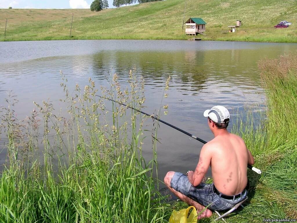 Рыбак на берегу водоема