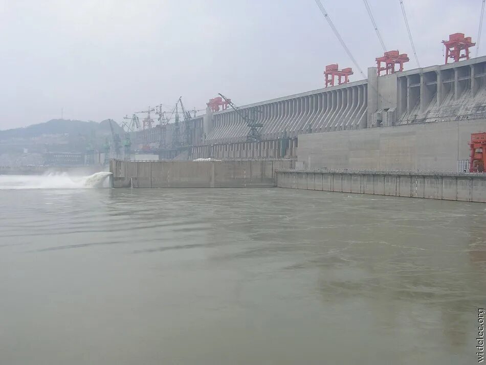Люди перегородили реку большой плотиной вода. Санься ГЭС. Три ущелья ГЭС. Асуанский гидроузел. Плотина 3 ущелья.