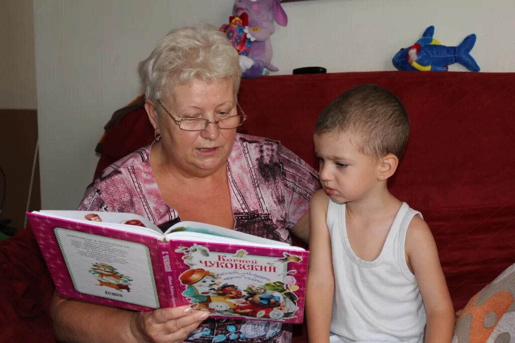 Мальчик читает бабушка
