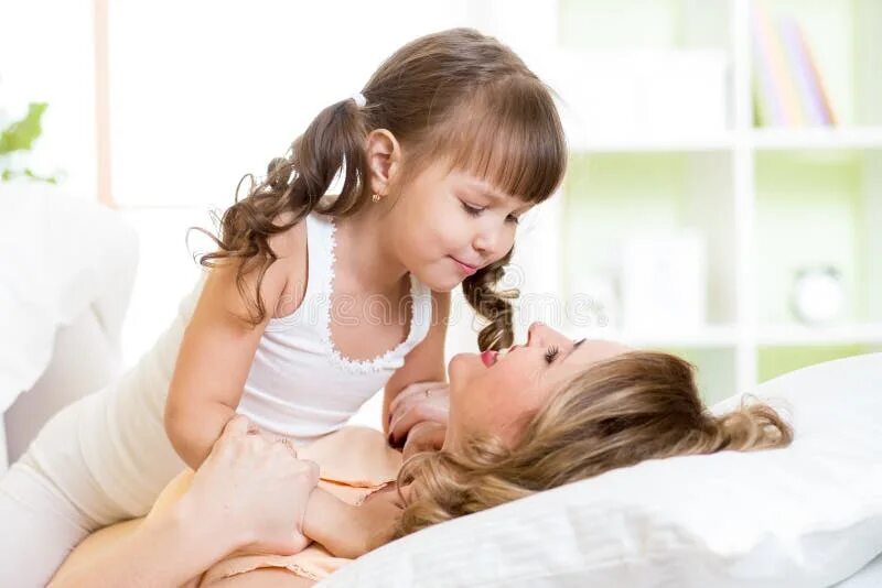 Возбужденные мать и дочь. Мама облизывает ребенка. Мама целует дочку в кровати. Мама с дочкой Облизываются.