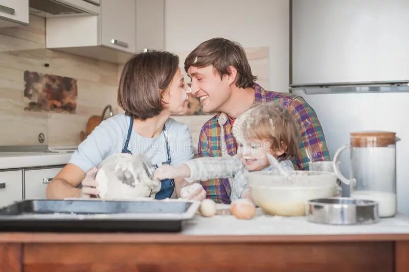 Семейная фотосессия на кухне с мукой. Семейная фотосессия на кухне с детьми с мукой. Семья готовит вместе мука. Приходит сын на кухню