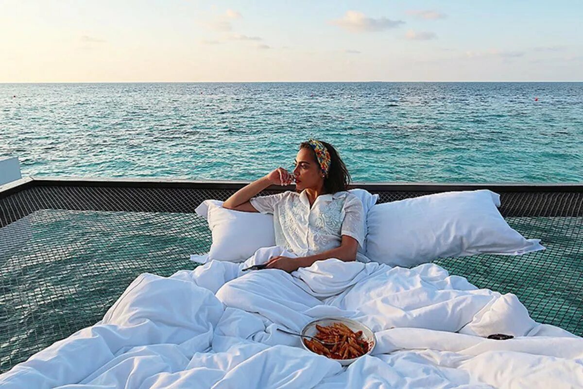 Отдыхать в постели. Кровать на море. Кровать в океане. Девушка на Мальдивах.