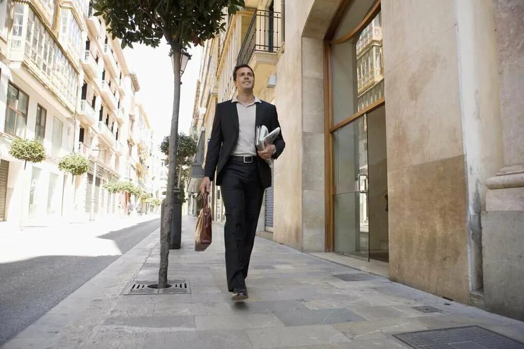 Человек идет с телефоном в руках. Успешный мужчина. Парень идет по улице. Мужчина идет по улице. Парень идет.