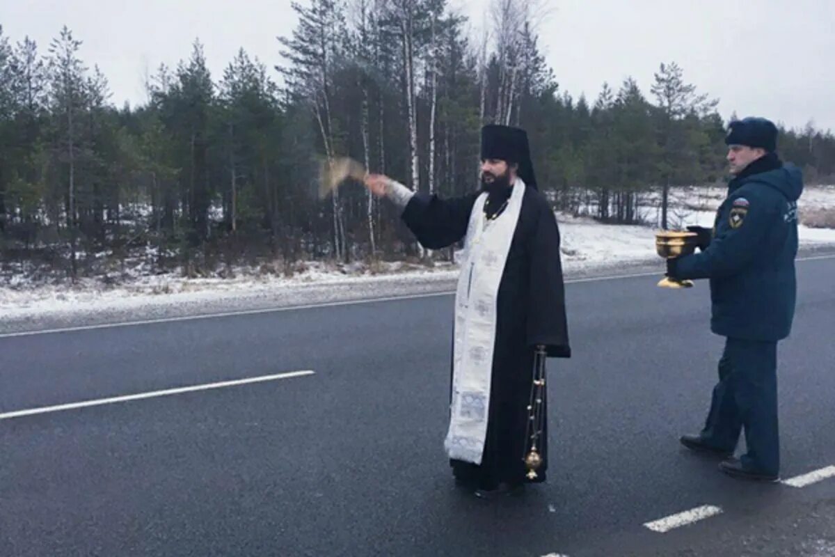 Брызгают святой водой. Освящение дороги. Священник освещает дорогу. Батюшка освящает дорогу. Священнослужители дорога.